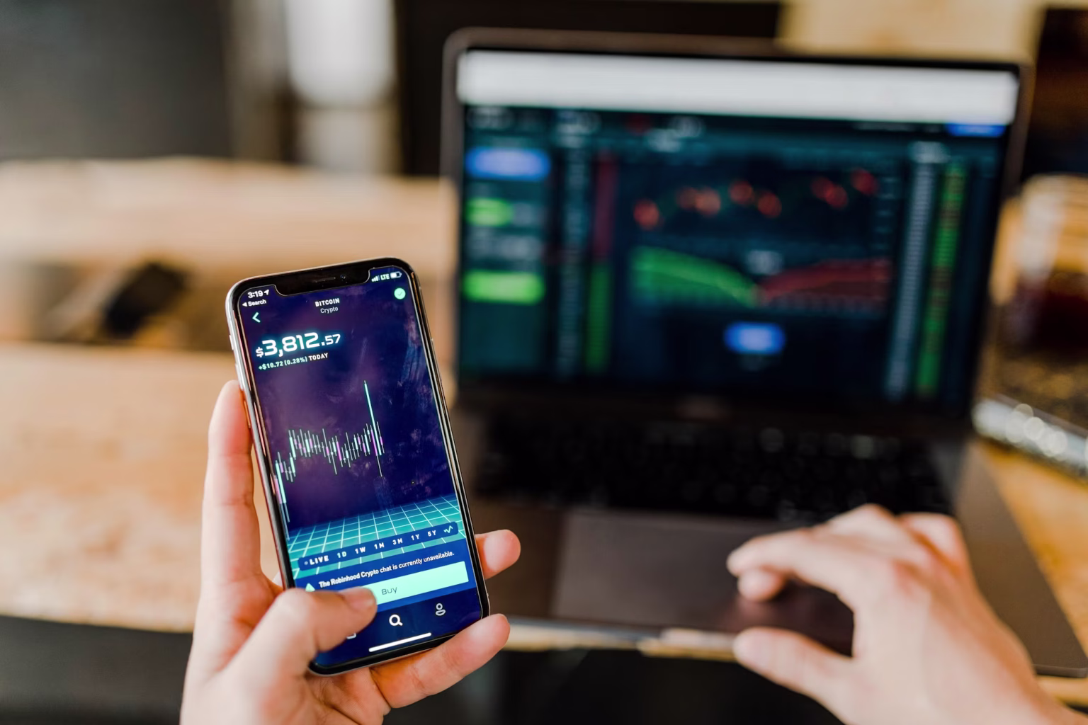 Developer holding phone next to laptop charts